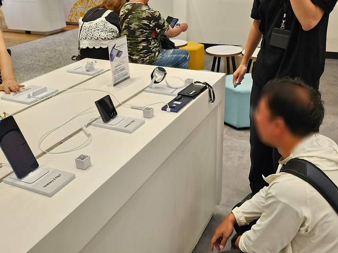 오사카 갤럭시 스튜디오에서 한 고객이 자신의 갤럭시Z폴드6와 신제품 갤럭시Z폴드7의 두께를 비교하고 있다. /김승한 기자