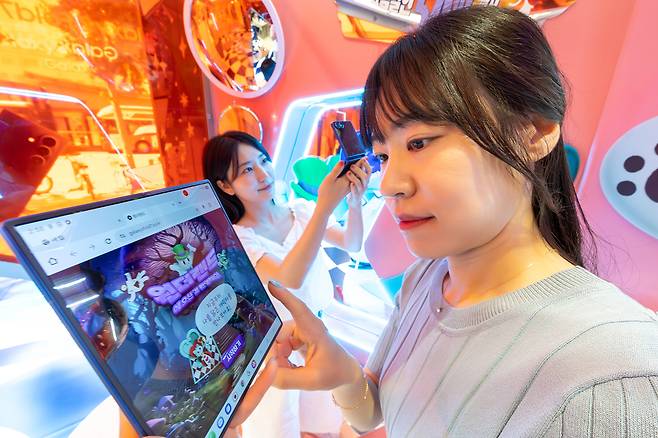 KT 모델들이 KT 홍대 애드샵 플러스에 마련된 ‘갤럭시 Z 폴더블7 AI 체험존’에서 AI 기반 콘텐츠를 체험하고 있다. [KT 제공]