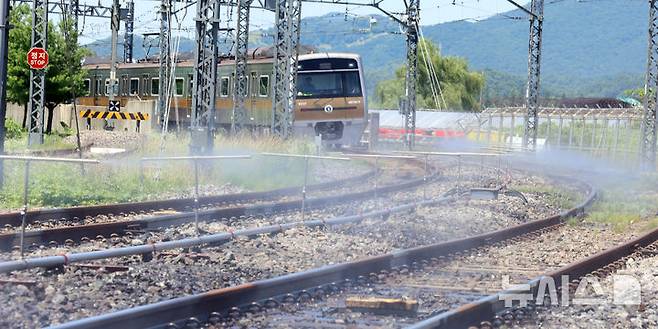 [서울=뉴시스] 전진환 기자 = 전국적인 폭염이 이어지고 있는 11일 서울 강서구 서울시메트로9호선 김포차량기지에서 운행을 마친 전동차가 들어오는 레일 주위로 '자동살수장치'가 가동되고 있다.  자동살수장치는 여름철 레일 온도가 일정 수준 이상으로 상승할 경우 자동으로 물을 분사해 온도를 낮추는 장치다. 2025.07.11. amin2@newsis.com