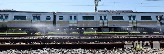 [서울=뉴시스] 전진환 기자 = 전국적인 폭염이 이어지고 있는 11일 서울 강서구 서울시메트로9호선 김포차량기지에서 운행을 마친 전동차가 들어오는 레일 주위로 '자동살수장치'가 가동되고 있다.  자동살수장치는 여름철 레일 온도가 일정 수준 이상으로 상승할 경우 자동으로 물을 분사해 온도를 낮추는 장치다. 2025.07.11. amin2@newsis.com