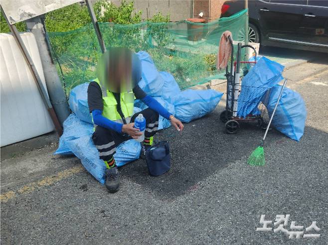 부산 강서구의 한 도로에서 무더위 속 청소 업무를 하던 환경미화원이 쓰레기 포대에 앉아 쉬고 있다. 정혜린 기자