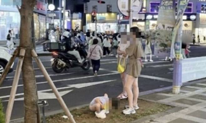 제주도 도심 한복판 인도변 화단에서 중국인으로 보이는 어머니가 용변을 보는 아이 옆에서 기다리고 있다. 온라인 커뮤니티 ‘에펨코리아’ 캡처