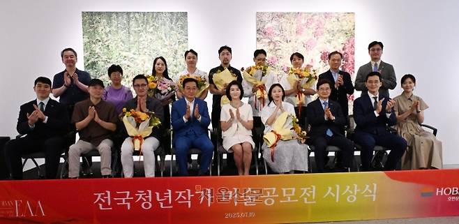 김상열 서울신문 회장과 우현희 호반문화재단 이사장이 10일 경기 과천 호반아트리움에서 열린 2025 전국청년작가 미술공모전(H-EAA) 시상식에서 수상 작가 등과 함께 기념 촬영을 하고 있다. 앞줄 왼쪽부터 김민성 호반그룹 기획관리실장, 권여현 홍익대 교수, 우수상을 받은 나광호 작가, 김 회장, 우 이사장, 대상을 받은 신민정 작가, 김선규 호반그룹 회장, 김대헌 호반그룹 기획총괄사장, 김민형 호반그룹 커뮤니케이션실 상무. 뒷줄 왼쪽부터 유진상 계원예술대 교수, 이선영 평론가, 고은주·박상빈·남정근·윤일권·김기태 작가, 장성환 호반문화재단 감사, 김동진 호반문화재단 이사. 안주영 전문기자