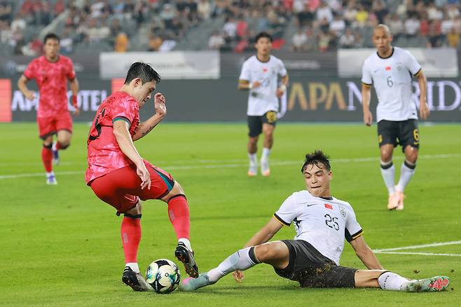 한국 이동경이 7일 동아시안컵 중국전에서 우미티장 위쑤푸 태클을 피하며 돌파하고 있다. 연합뉴스