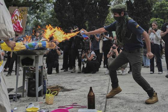 2025년 7월 4일 멕시코시티에서 미국인 증가로 인해 주택 가격이 오르면서 젠트리피케이션이 나타나자, 이에 반대하는 시위가 벌어졌다. 한 시위자가 도널드 트럼프 미국 대통령의 모형을 불태우고 있다. AP=연합뉴스