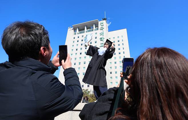 A Konkuk University student takes a photo at her graduation ceremony held on Feb. 21. [YONHAP]