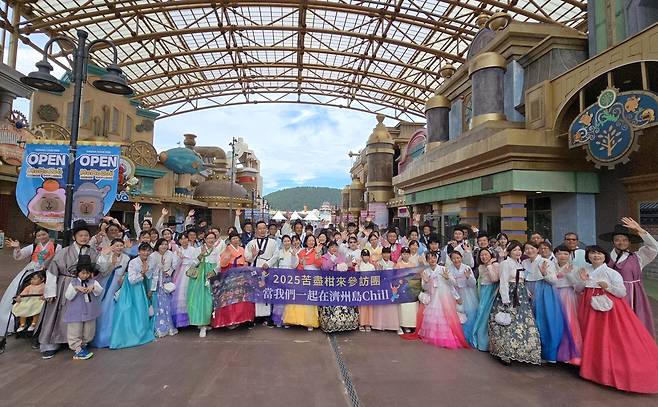 11일 제주신화월드 테마마크에서 한복을 차려입은채 드라마 ‘폭싹 속았수다’의 테마인 고진감래를 한글자 한글자 외치고 있는 대만·홍콩 관광객들.[함영훈 기자]