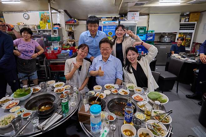 이재명 대통령이 11일 저녁 서울 광화문 인근 한 식당에서 ‘대통령과 외식합니다’ 행사를 갖고 대통령실 직원 등 참석자들과 기념촬영을 하고 있다. <연합>