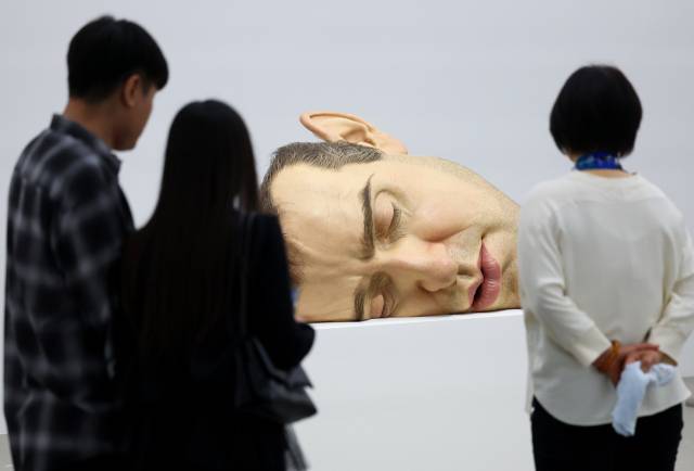 국립현대미술관 서울에서 전시한 론 뮤익의 자화상 '마스크 II'를 관람하는 모습. 연합뉴스