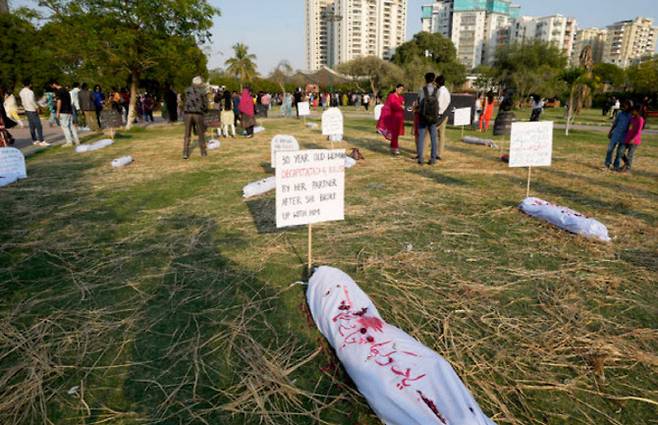 사회주의-페미니스트 단체 활동가들이 지난해 3월8일 파키스탄 카라치에서 열린 국제 여성의 날 기념 집회에서 명예 살인과 가정 폭력으로 희생된 여성들의 모조 시신을 전시하고 있는 모습. AP