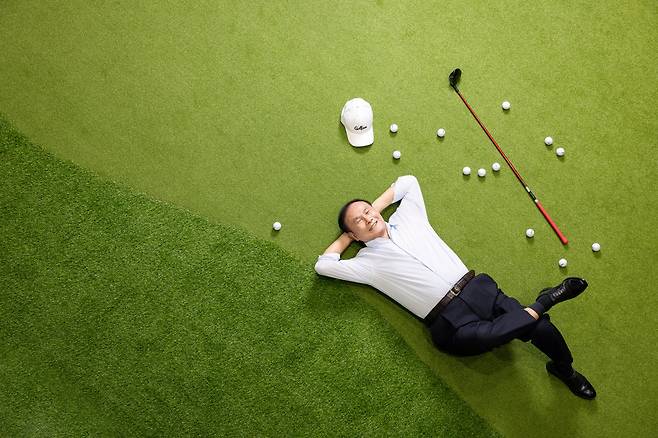 김영찬 골프존그룹 회장이 대전 유성구 ‘골프존 조이마루’에 있는 퍼팅 연습 그린 위에 누워 있다. 아시아 골프 산업에서 가장 영향력 있는 인물 1위에 3년 연속 선정된 그는 스크린 골프장으로 골프의 대중화를 이끌었다는 평가를 받는다. /장은주 영상미디어 기자