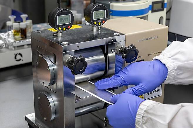 연구진이 전사 인쇄 장비로 리튬 전극과 보호막을 눌러 결합시키고 있다./한국화학연구원