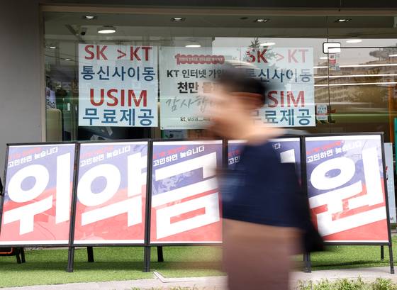 A sign is seen at a telecommunications store in downtown Seoul on July 7, reminding consumers of the waived early termination fees for subscribers leaving SK Telecom. [YONHAP]