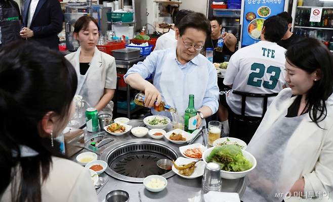 [서울=뉴시스] 최동준 기자 = 이재명 대통령이 11일 서울 종로구 한 식당에서 시민들과 '삼겹살 외식'을 하고 있다.  이 대통령은 SNS에 식사 계획을 알리며 "이처럼 어려운 시기에 21일부터 시행되는 민생회복 소비쿠폰 정책이 내수 진작과 지역 경제 활성화에 활력을 불어넣길 기대한다"고 밝혔다. (대통령실통신사진기자단) 2025.07.11. photocdj@newsis.com /사진=최동준