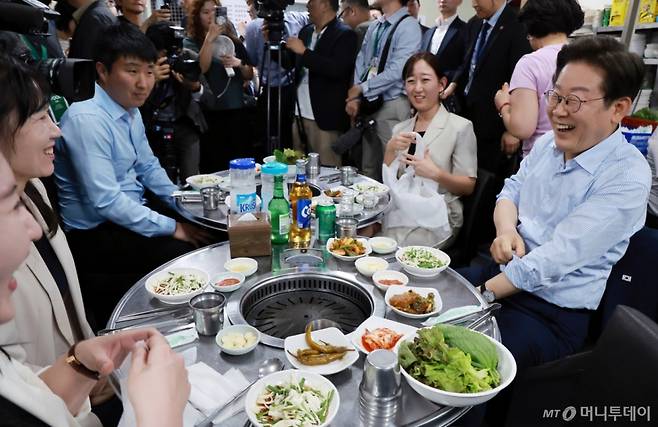 [서울=뉴시스] 최동준 기자 = 이재명 대통령이 11일 서울 종로구 한 식당에서 시민들과 '삼겹살 외식'을 하고 있다.  이 대통령은 SNS에 식사 계획을 알리며 "이처럼 어려운 시기에 21일부터 시행되는 민생회복 소비쿠폰 정책이 내수 진작과 지역 경제 활성화에 활력을 불어넣길 기대한다"고 밝혔다. (대통령실통신사진기자단) 2025.07.11. photocdj@newsis.com /사진=최동준
