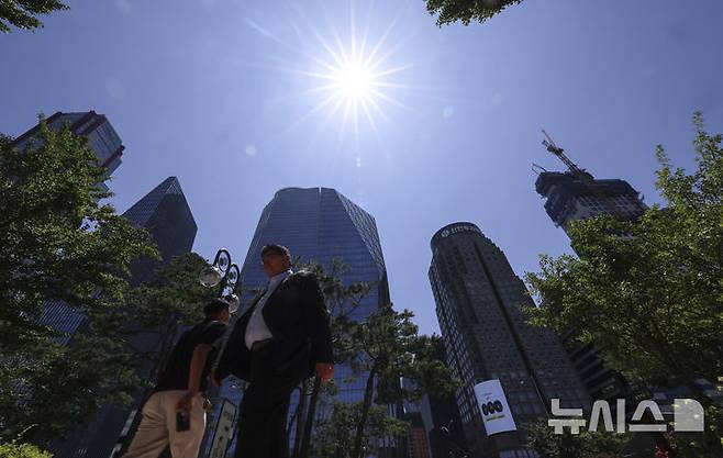 [서울=뉴시스] 김근수 기자 = 연일 폭염이 계속되는 가운데 11일 서울 영등포구 여의도 공원에서 직장인들이 점심식사를 하기 위해 이동하고 있다. 2025.07.11. ks@newsis.com