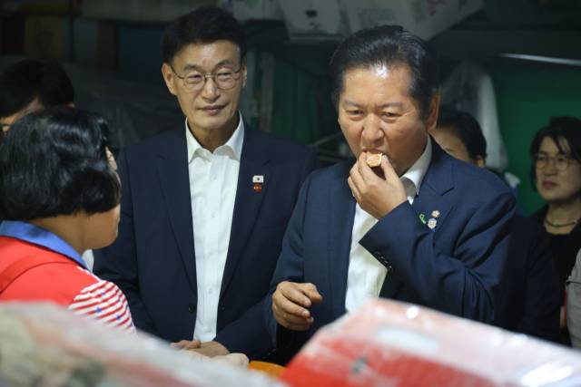 더불어민주당 당 대표 후보인 정청래 의원이 13일 제주시 동문재래시장을 찾아 도민들과 인사하던 중 상인이 건넨 감귤을 맛보고 있다. 연합뉴스