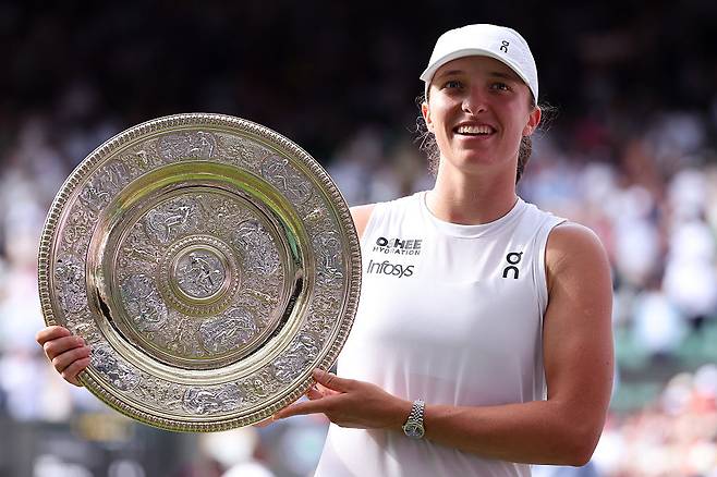 이가 시비옹테크(폴란드)가  12일(현지시간) 영국 런던의 올잉글랜드 클럽에서 열린 윔블던 테니스대회 여자 단식 결승에서 어맨다 아니시모바(미국)를 꺾고 우승한 뒤 트로피와 함께 활짝 웃고 있다. 게티이미지코리아