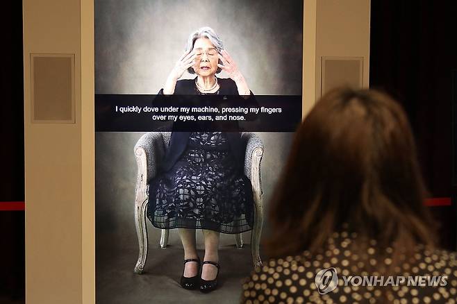히로시마 피폭자의 경험담 증언 영상 (히로시마=연합뉴스) 박상현 특파원 = 1945년 일본 히로시마에 원자폭탄이 투하됐을 당시 14세였던 가지모토 요시코 씨가 했던 피폭 경험담을 영상으로 보여주는 '피폭증언 응답장치'. 지난 9일 NHK 히로시마 방송국에서 한 여성이 응답장치에 질문한 뒤 대답을 듣고 있다.