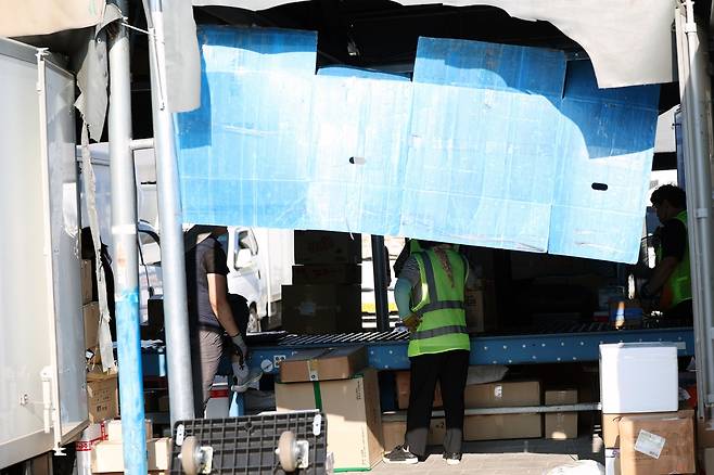 임시방편으로 가린 태양빛 (광주=연합뉴스) 천정인 기자 = 폭염특보가 이어진 지난 11일 오전 광주 광산구 한 택배회사 물류창고에서 노동자들이 뜨거운 햇빛을 가려놓고 분류 작업을 하고 있다. 2025.7.13    iny@yna.co.kr