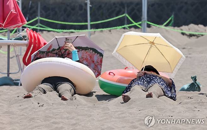 해변의 모래 찜질 (제주=연합뉴스) 지난 7월 3일 오전 제주시 삼양해수욕장을 찾은 피서객이 모래 찜질을 하고 있다. [연합뉴스 자료사진]