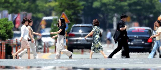 부산지역에 폭염특보가 이어진 지난 2일 해운대구 벡스코 인근 도로에서 시민들이 지열로 아지랑이가 피어오르는 횡단보도를 건너고 있다. 정종회 기자 jjh@