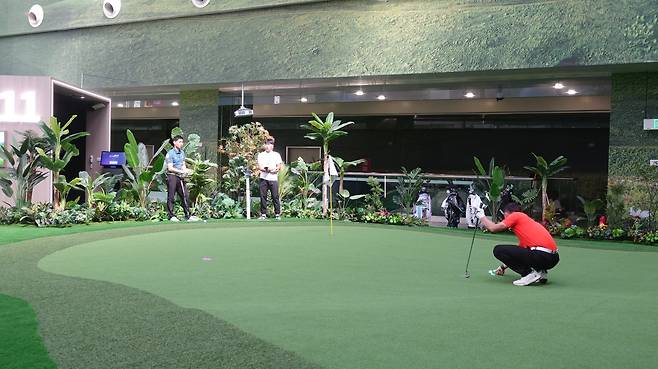 골프존이 중국에서 처음 선보인 시티골프. 티샷 등을 스크린에서 한 뒤 공이 주변 근처에 떨어지면 스크린장이 열리며 그린 구역이 나타난다. 그린까지 걸어가 실제처럼 퍼팅할 수 있다. /골프존