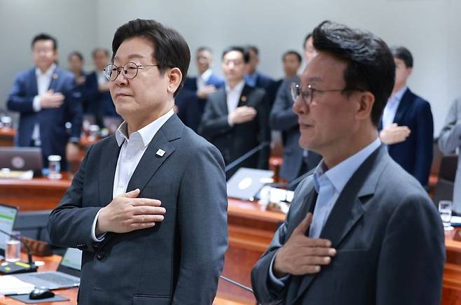 이재명 대통령이 지난 8일 용산 대통령실에서 열린 국무회의 에서 국기에 경례하고 있다. 오른쪽은 김민석 국무총리 ⓒ연합뉴스
