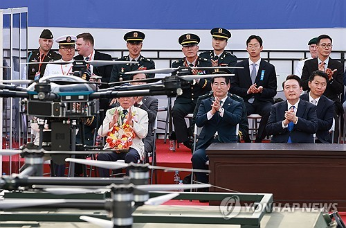 윤석열 대통령이 2024년 10월 1일 서울 광화문 일대에서 열린 국군의날 시가행진 중 세종대왕상 앞 관람 무대 앞을 지나는 드론을 바라보고 있다.   [연합뉴스]