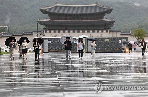비가 내린 14일 서울 종로구 광화문광장에서 시민들이 이동하고 있다.  [연합뉴스]