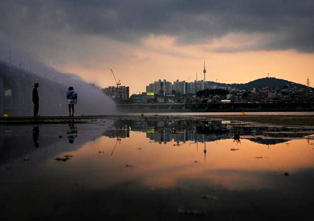 불볕더위와 폭우가 번갈아 왔던 8일 반포 한강공원에 비바람이 물러가자, 먹구름 사이로 붉은 노을이 번지고 있다.