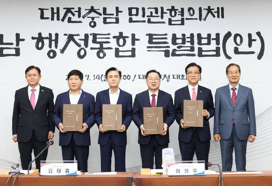 김태흠 충남지사(왼쪽 셋째)와 이장우 대전시장(오른족 셋째)이 14일 대전시청에서 열린 대전충남 행정통합 특별법(안) 증정식에서 민간협의체로부터 법률안을 전달받고 있다. [사진 대전시]