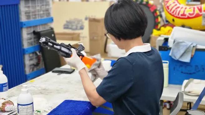 A volunteer dries off a water gun discarded after the Waterbomb festival at the office of nonprofit organization TRU in Goyang, Gyeonggi Province, on July 10.