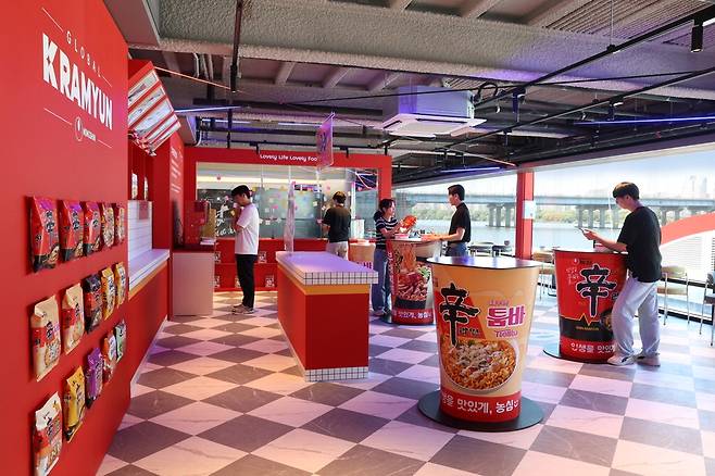 농심 한강버스 여의도·잠실 선착장에 있는 '너구리의 라면가게'. 내부는 지난 3월 출간된 동화책 '너구리 라면가게'에 묘사된 공간을 테마로 삼고 너구리 캐릭터 포토존과 대형 컵라면 모양의 테이블, 농심 K라면 상징 연출물로 꾸며졌다. 농심은 한강버스 선착장 너구리의 라면가게를 통해 수상 대중교통 이용객은 물론 한강공원을 찾은 관광객을 대상으로 브랜드 인지도를 높일 계획이다.