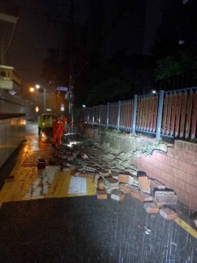 이틀간 집중된 호우로 14일 새벽 부산 수영구 망미동 근린공원 담벼락이 파손됐다. 부산소방재난본부 제공