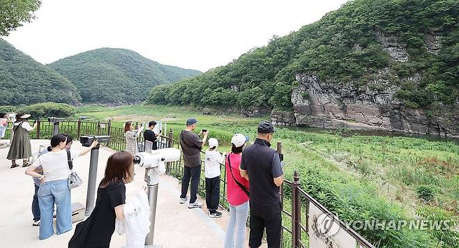 관람객으로 북적이는 '세계유산' 반구대 암각화 (울산=연합뉴스) 김용태 기자 = 13일 울산시 울주군 대곡리 반구대 암각화 전망대에서 시민이 망원경으로 암각화를 관람하고 있다. 지난 12일 '울주 대곡리 반구대 암각화'와 '울주 천전리 명문과 암각화'로 구성된 '반구천의 암각화'가 유네스코 세계유산으로 등재됐다. 2025.7.13 yongtae@yna.co.kr