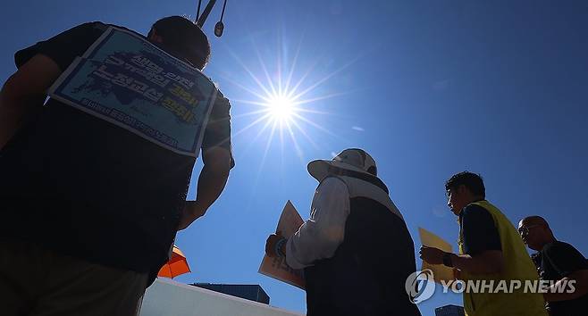 내리쬐는 뙤약볕 아래 휴식권 보장 촉구하는 노동자 7월 11일 서울 종로구 정부서울청사 앞에서 정부 규제개혁위원회(규개위)의 폭염 규칙 통과 촉구 기자회견을 하는 민주노총 조합원 위로 뙤약볕이 내리쬐고 있다.[연합뉴스 자료사진]