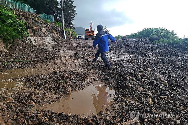 통제된 울릉 도로 (울릉=연합뉴스) 14일 경북 울릉군 북면 현포리 도로에 흙과 돌이 쏟아져 울릉군이 장비와 인력을 동원해 치우고 있다. 2025.7.14 [울릉군 제공. 재판매 및 DB 금지] sds123@yna.co.kr