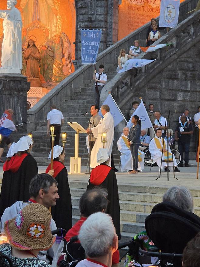 로사리오 촛불 행렬 후  유순엽 요셉 형제가 대한민국 순례단 대표로 한국말로 된 성모송을 선창하고 있다.