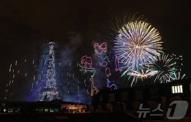 14일(현지시간) 프랑스 혁명 기념일(바스티유 데이)을 기념하기 위해 에펠탑에 펼쳐진 불꽃놀이 쇼에서 불꽃과 함께 1천100대의 드론이 여러 동물의 형상을 연출하고 있다. 2024.7.15/뉴스1 ⓒ News1 이준성 기자