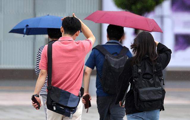 비가 내린 15일 대구 동구 동대구역 광장에서 우산을 준비하지 못한 시민들이 손으로 머리를 가린 채 이동하고 있다. 뉴시스