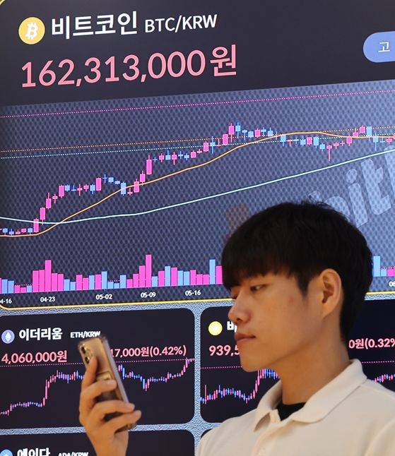 비트코인이 14일 글로벌마켓에서 사상 처음으로 개당 12만 달러선을 넘었다. 사진은 이날 오전 서울 서초구 빗썸라운지 강남 본점 현황판에 표시된 비트코인 시세. [연합뉴스]