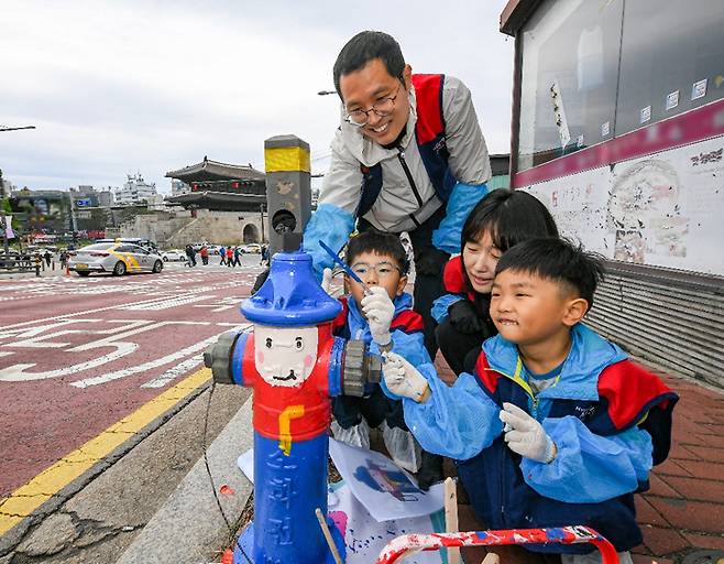 현대모비스 임직원과 가족이 지상식 소화전을 색칠하고 있다. 현대모비스 제공