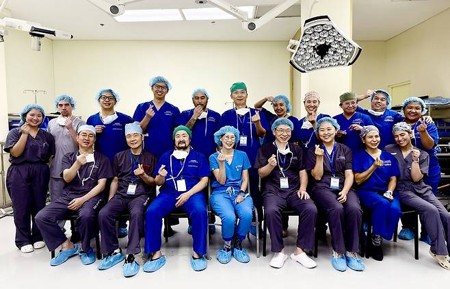 서울아산병원 간이식팀이 지난 달 18일 필리핀 마카티병원에서 생체 간이식 수술을 성공하고 필리핀 현지 의료진과 함께 수술실 앞에서 기념사진을 촬영하고 있다. 서울아산병원 제공