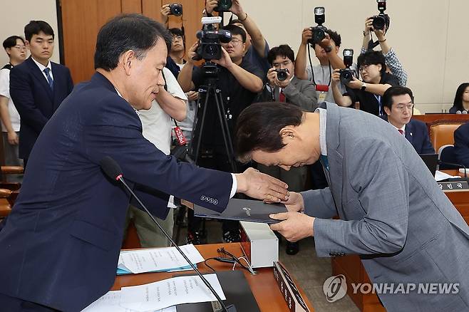 '깍듯한 인사' (서울=연합뉴스) 김주성 기자 = 권오을 국가보훈부 장관 후보자가 15일 국회 정무위원회에서 열린 인사청문회에서 선서 후 윤한홍 위원장에게 선서문을 전달하고 있다. 2025.7.15 utzza@yna.co.kr