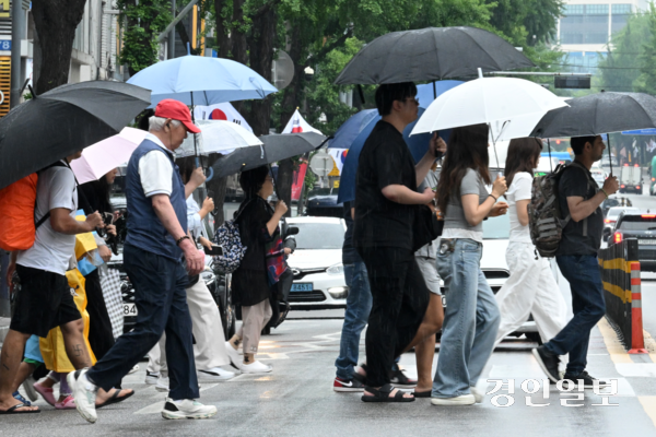 비가 내리며 흐린 날씨가 이어진 16일 오후 수원시내 한 횡단보도에서 우산을 쓴 시민들이 발걸음을 재촉하고 있다. 2025.7.16 /최은성기자 ces7198@kyeongin.com