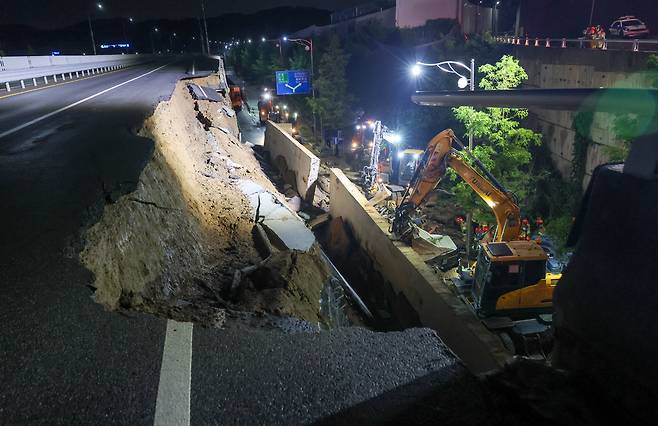 ▲ 경기도 대부분 지역에 호우주의보가 내려진 16일 오후 오산시 가장교차로 고가도로 옹벽이 무너져 소방관들이 매몰된 차량구조 작업을 하고 있다./전광현 기자 maggie@incheonilbo.com
