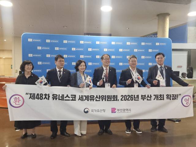 15일(현지 시간) 프랑스 파리에서 열린 제47차 유네스코 세계유산위원회에서 차기 행사 개최지로 대한민국 부산이 확정되자 대표단이 환영 현수막을 들고 기뻐하고 있다. 국가유산청 제공