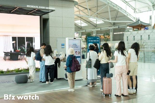 GS건설 자이 팝업스토어를 경험하기 위해 여행객들이 포토키오스크 앞에서 줄을 서고 있다./사진=GS건설 제공