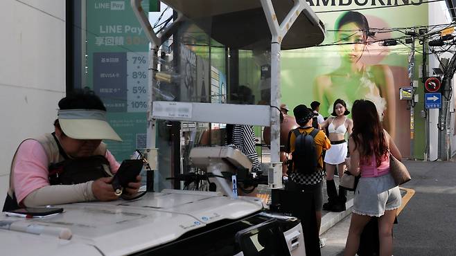 사진을 찍기 위해 줄 선 관광객들 사이로 요구르트 판매원이 자리를 지키며 영업을 하고 있다. / 고운호 기자